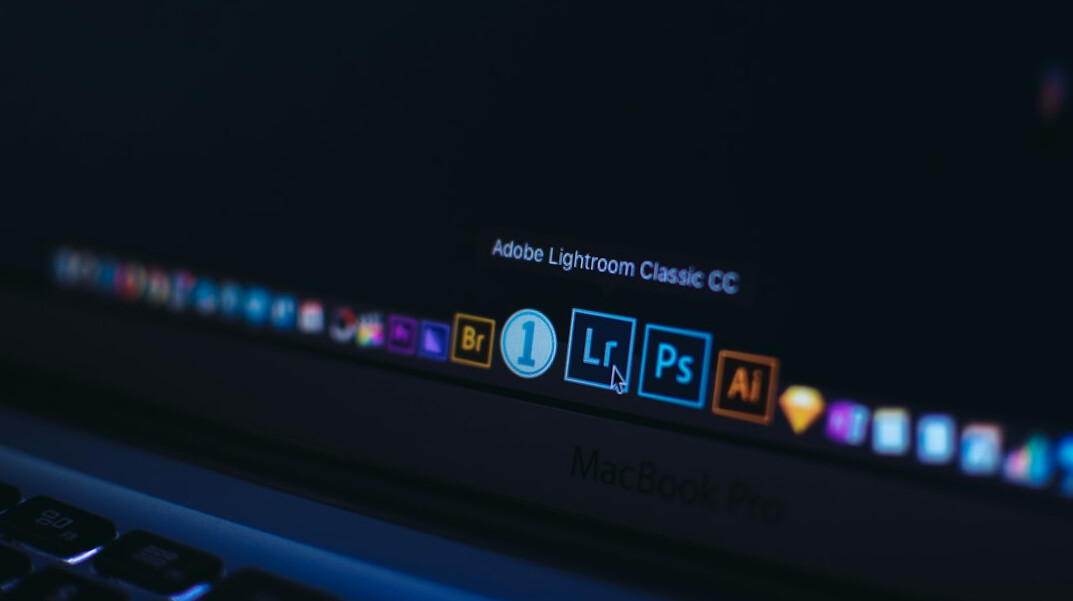 Developer writing code on a laptop in a bright modern office